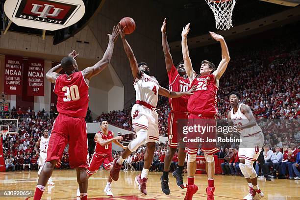 Ethan Happ, Nigel Hayes and Vitto Brown of the Wisconsin Badgers defend against Robert Johnson of the Indiana Hoosiers in the first half of the game...