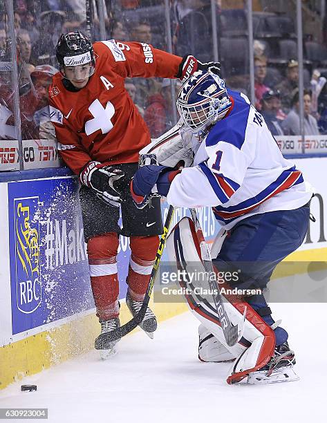 Tyler Parsons of Team USA bumps into Damien Riat of Team Switzerland during a QuarterFinal game at the 2017 IIHF World Junior Hockey Championships at...