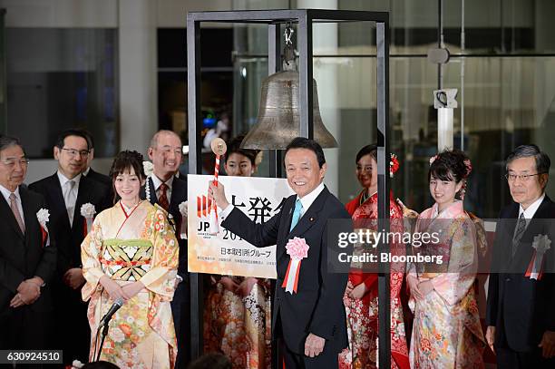 Taro Aso, Japan's finance minister, poses for a photograph before he rings the opening bell during a ceremony marking the first trading day of the...