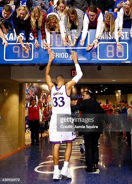 Landen Lucas of the Kansas Jayhawks high-fives fans as he walks off the court after the Jayhawks defeated the Kansas State Wildcats 90-88 to win the...