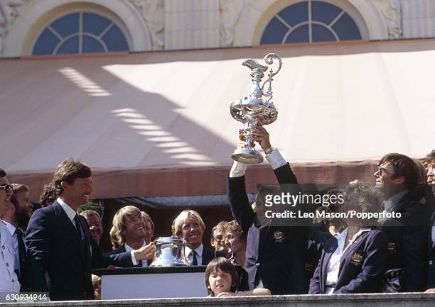 Alan Bond, the Australian businessman and leader of the syndicate which owned the victorious Australia II, holding the trophy during the presentation...