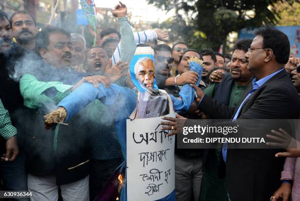 Indian activists of the Trinamool Congress shout slogans as they burn an effigy of Prime Minister Narendra Modi during a protest meeting in Siliguri...