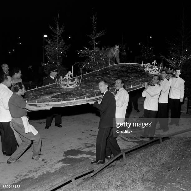 People carry the biggest king cake of the wolrd, which is 6,27 meters long X 2,60 meters wide, on January 05, 1961 in a well-known restaurant on the...