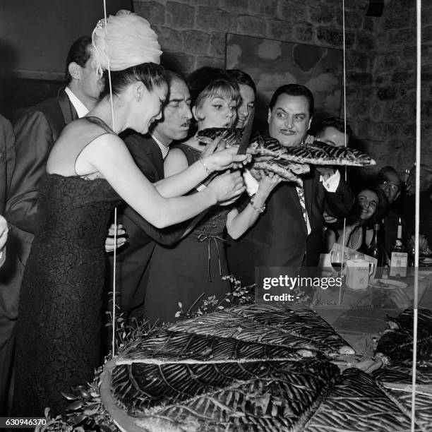 From L to R, french model Lucky, french clown and circus operator Achille Zavatta, french singer Annie Cordy and french singer Dario Moreno eat a...