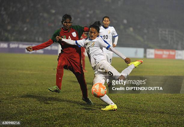 Indian footballer Kamala Devi Yumnam vies for the ball with Bangladesh footballer M Nargis Khatun as Indian captain Bala Devi Ngangom looks on during...