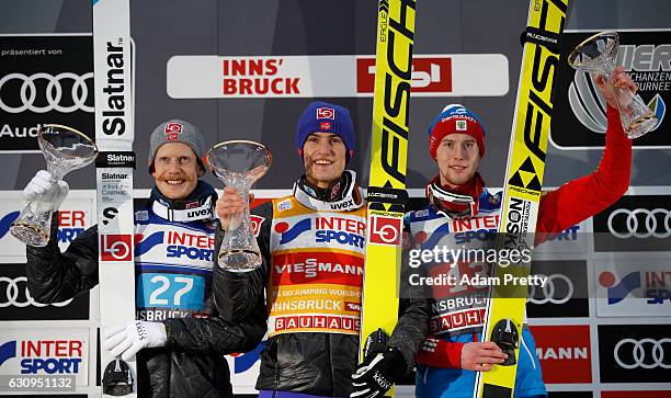 Second placed Robert Johansson of Norway, winner Daniel Andre Tande of Norway and third placed Evgeniy Klimov of Russia pose on the podium after the...