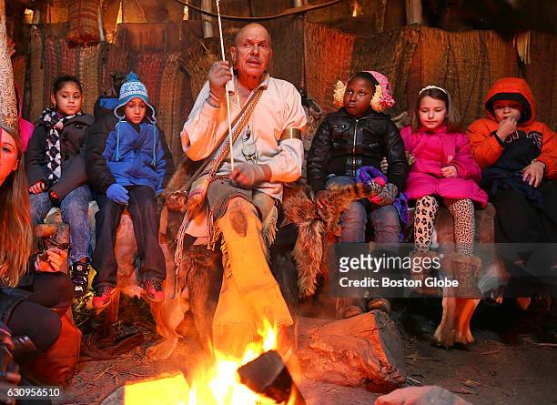 Choctaw Indian Jon Rice tells stories to children sitting around his fire inside a wetu at the Wampanoag Homesite at Plimoth Plantation in Plymouth,...