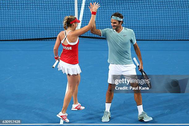 Roger Federer and Belinda Bencic of Switzerland celebrate after winning a point during the mixed doubles match against Alexander Zverev and Andrea...