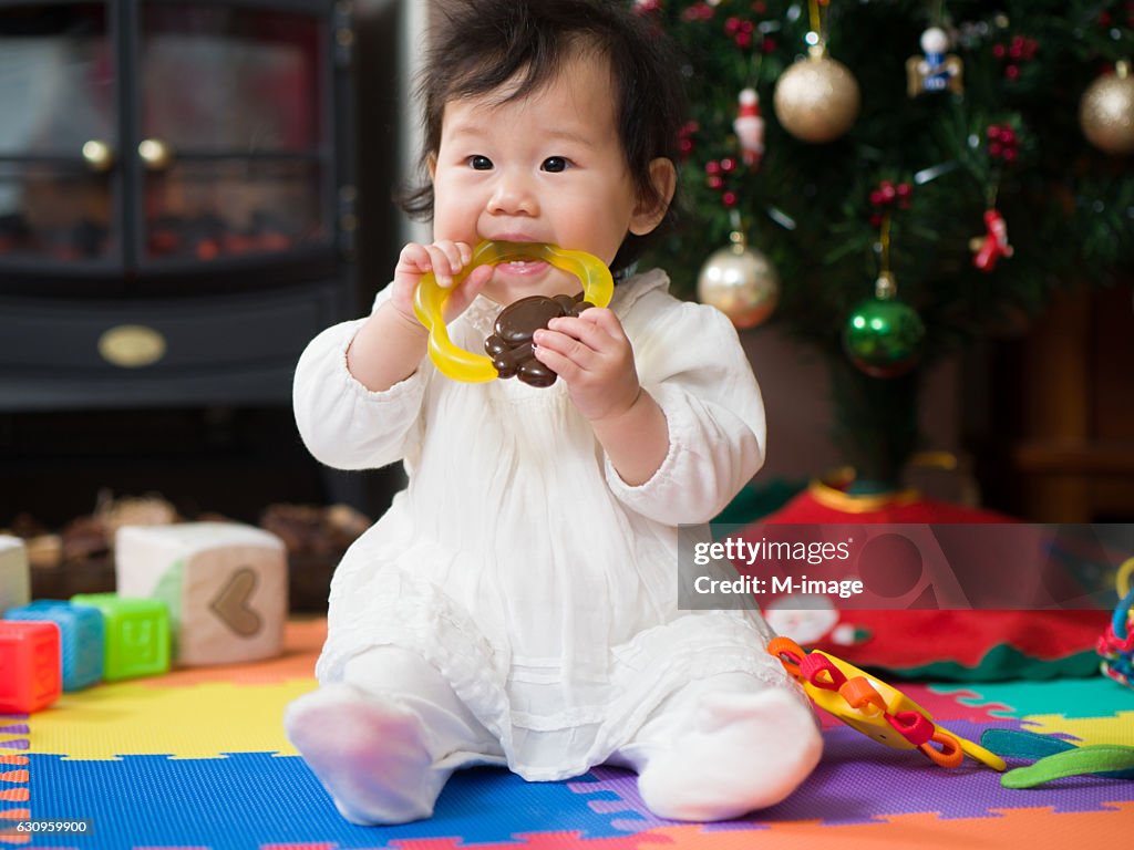 Teething baby girl playing with teething toy