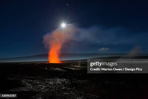 full moon over halemaumau crater within the much larger summit caldera of kilauea in hawaii volcanoes national park, steaming vents in foreground, mauna loa mountain in background - cratera de halemaumau - fotografias e filmes do acervo