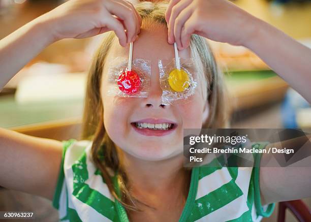 young girl holding suckers over her eyes: richmond, british columbia, canada - brechin maclean stock pictures, royalty-free photos & images