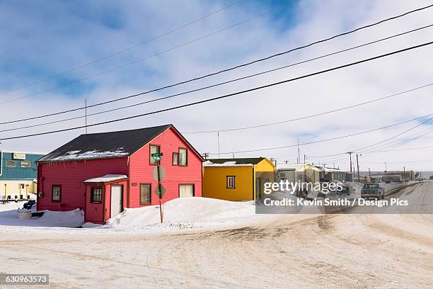 a street lined with pink and yellow houses, barrow, north slope, arctic alaska, usa, winter - barrow alaska photos et images de collection