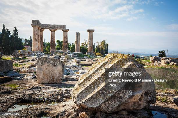 stone ruins with columns and a boulder - templo de apolo corinto imagens e fotografias de stock