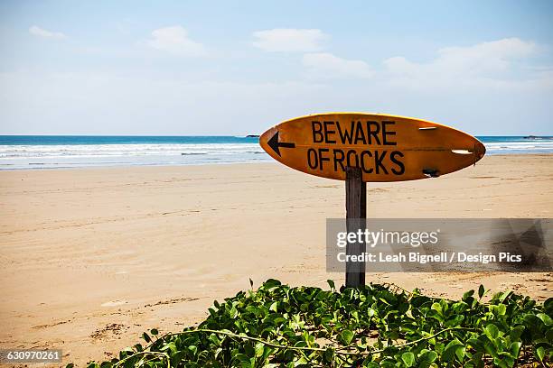 a warning sign on a surfboard in playa hermosa - san juan del sur bildbanksfoton och bilder