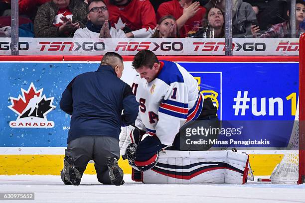 Medic tends to goaltender Tyler Parsons of Team United States during the 2017 IIHF World Junior Championship semifinal game against Team Russia at...