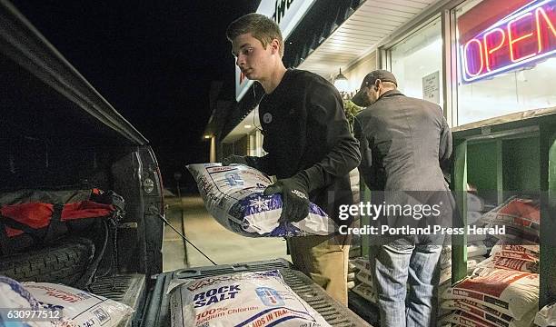 Ace/Oak Hill Hardware employee Jimmy Dugan helps Scarborough resident Nate Marcoux load rock salt into Marcoux's truck in preparation for Thursday's...