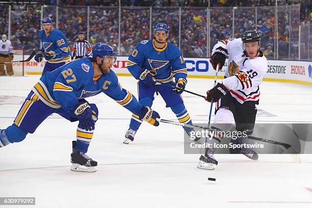 Chicago Blackhawks center Jonathan Toews takes a shot on goal while St. Louis Blues defenseman Alex Pietrangelo tries to block the shot during a NHL...