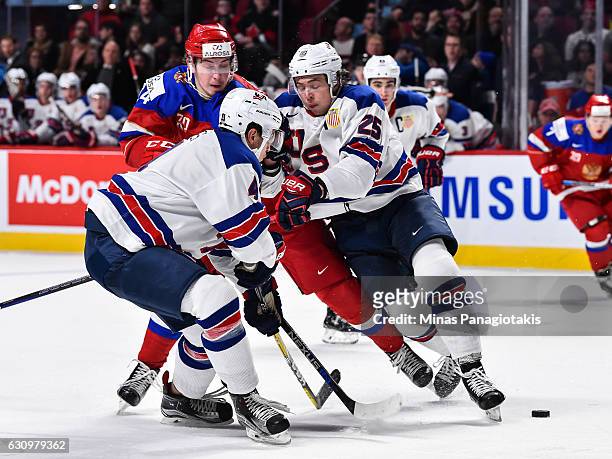 Mikhail Vorobyev of Team Russia gets caught between Caleb Jones and Charlie McAvoy of Team United States during the 2017 IIHF World Junior...