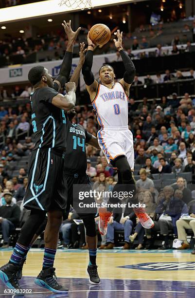 Russell Westbrook of the Oklahoma City Thunder drives to the basket against teammates Roy Hibbert and Michael Kidd-Gilchrist of the Charlotte Hornets...