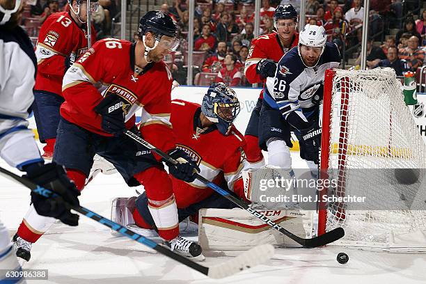 Goaltender Roberto Luongo of the Florida Panthers defends the net with the help of teammate Jakub Kindl against the Winnipeg Jets at the BB&T Center...