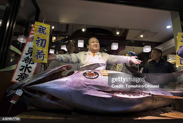 Kiyomura Co. President Kiyoshi Kimura poses with a fresh bluefin tuna in front of one of the company's Sushi Zanmai sushi restaurants after the...