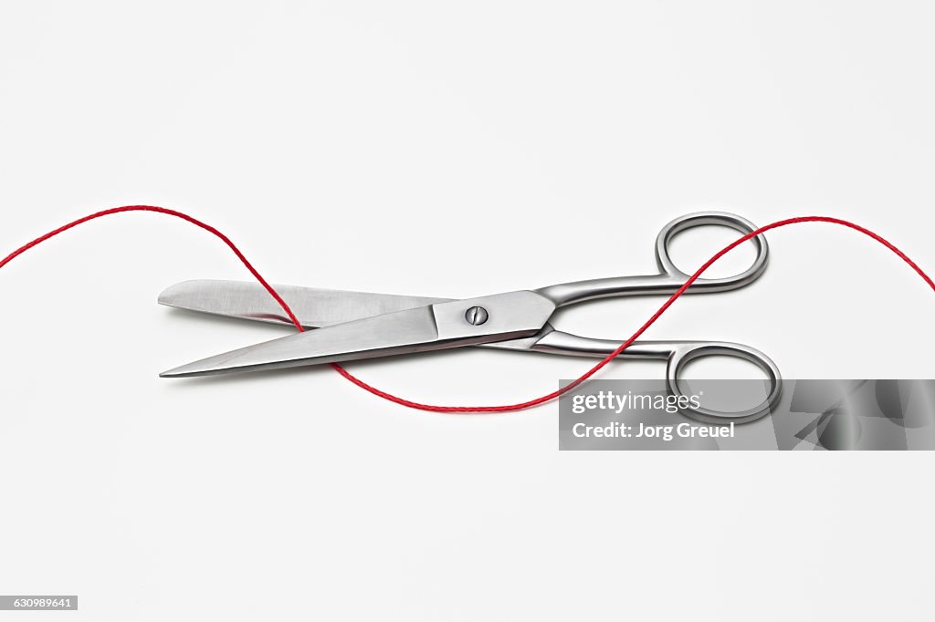 Scissors Cutting Red String High-Res Stock Photo - Getty Images