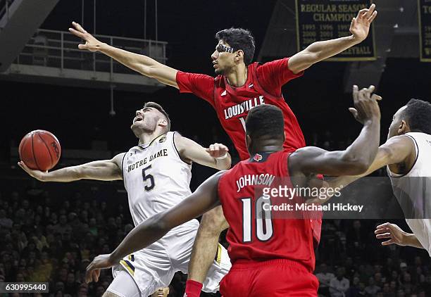 Matt Farrell of the Notre Dame Fighting Irish shoots the ball as Anas Mahmoud of the Louisville Cardinals defends over the top at Purcell Pavilion on...