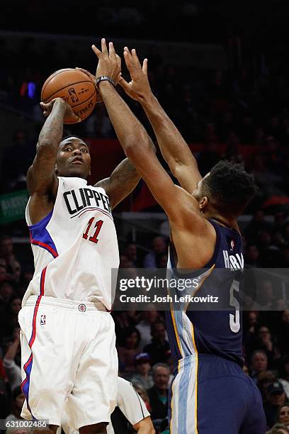 Jamal Crawford of the Los Angeles Clippers shoots a three-pointer against Andrew Harrison of the Memphis Grizzlies during a game against the Memphis...