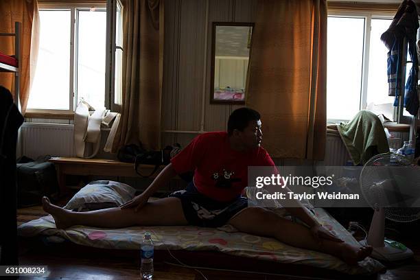 Wrestler stretches in his dorm at a sumo wrestling training camp on the outskirts of Ulaanbaatar, Mongolia on Tuesday, July 26, 2016. Khishigbat...