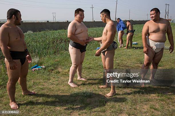 Wrestlers chat before a practice session at a sumo wrestling training camp on the outskirts of Ulaanbaatar, Mongolia on Tuesday, July 26, 2016.