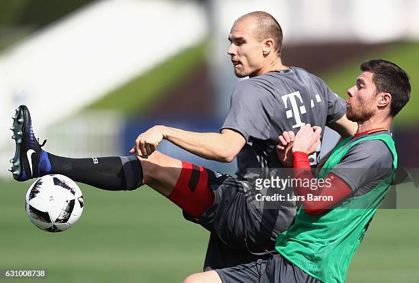 Holger Badstuber is challenged by Xavi Alonso during a training session at day 3 of the Bayern Muenchen training camp at Aspire Academy on January 5,...