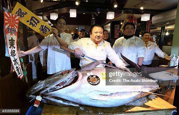 Kiyomura Co. President Kiyoshi Kimura poses with a fresh bluefin tuna before cutting it in front of one of the company's Sushi Zanmai sushi...