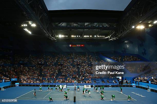 Ball kids dry the court with towels following a brief rain shower during the women's singles match between Daria Gavrilova of Australia and Coco...