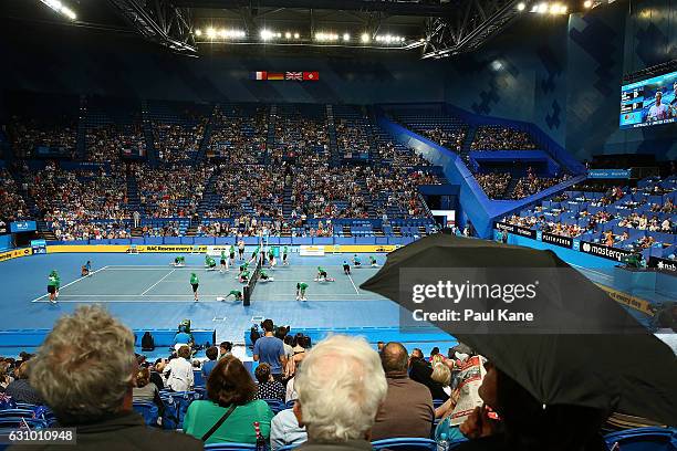 Spectators shelter from the rain as ball kids dry the court with towels during the women's singles match between Daria Gavrilova of Australia and...