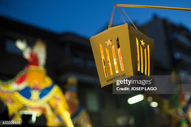 Float passes by a paper lantern cut-out of an Estelada, a Catalan Pro-independence flag during the Three Wise Men Parade in Vic on January 5 marking...