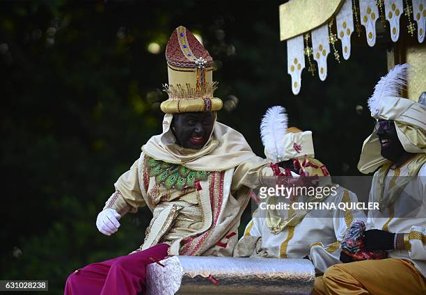 Man dressed as King Balthazar, one of the three wise men or the Three Kings throws candies during the Three Wise Men Parade in Sevilla on January 5...