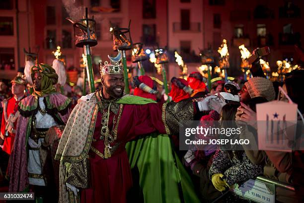 Man dressed as King Balthazar, one of the three wise men or the Three Kings shakes hands during the Three Wise Men Parade in Vic on January 5 marking...