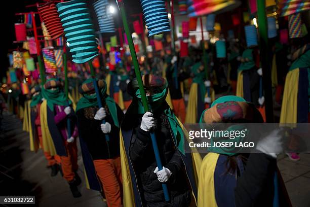 Disguised participants hold paper lanterns as they parade during the Three Wise Men Parade in Vic on January 5 marking the eve of the feast of...