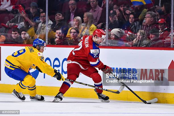 Danil Yurtaikin of Team Russia skates the puck against Tim Soderlund of Team Sweden during the 2017 IIHF World Junior Championship bronze medal game...