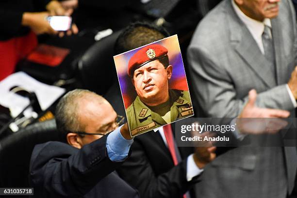 Pro government deputy holding a banner with the face of late Venezuelan President Hugo Chavez inside the National Assembly in Caracas, Venezuela on...