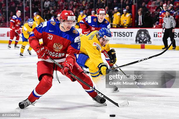 Denis Guryanov of Team Russia skates the puck against David Bernhardt of Team Sweden during the 2017 IIHF World Junior Championship bronze medal game...