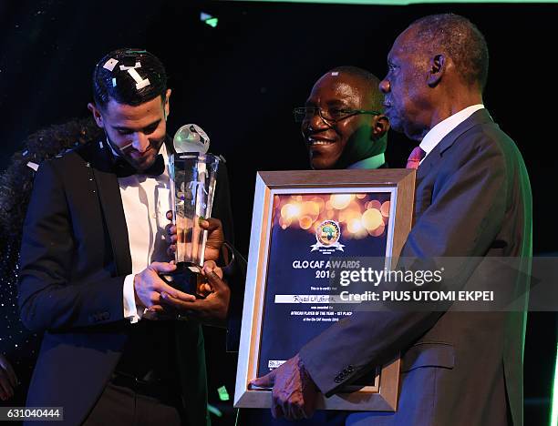 Algerian and Leicester forward Riyad Mahrez receives trophy from Nigeria's Sports Minister Solomon Dalung and CAF President Issa Hayatou after being...