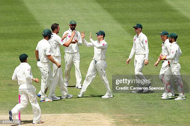 Australian captain Steve Smith celebrates catching Yasir Shah of Pakistan off a delivery by team mate Josh Hazlewood during day four of the Third...