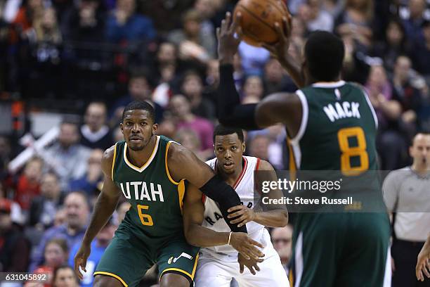 Toronto Raptors guard Kyle Lowry keeps Utah Jazz forward Joe Johnson close by as Shelvin Mack looks for someone to pass to as the Toronto Raptors...