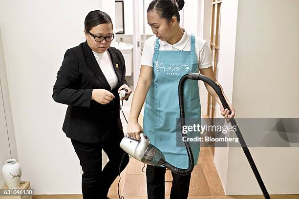 Housekeeping trainer Contessa Tadena, left, assists trainee Maria Del Bago vacuuming in a Japanese style apartment during a training session at the...