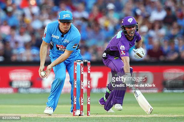 Brad Hodge of the Adelaide Strikers attempts but fails to run-out Jonathan Wells of the Hobart Hurricanes during the Big Bash League match between...