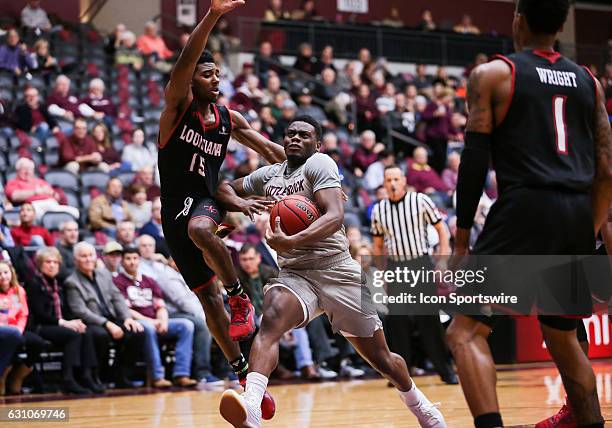 Arkansas Little Rock Trojans guard Kemy Osse drives to the basket as Louisiana Lafayette Ragin Cajuns guard P.J. Hardy guards him during an NCAA...