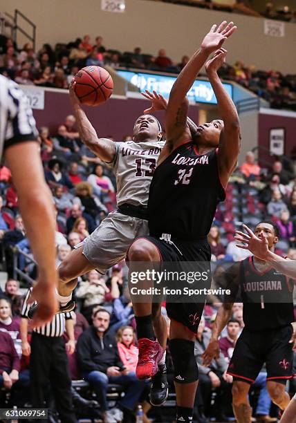 Arkansas Little Rock Trojans guard Marcus Johnson Jr. Tries to shoot around Louisiana Lafayette Ragin Cajuns forward Bryce Washington during an NCAA...