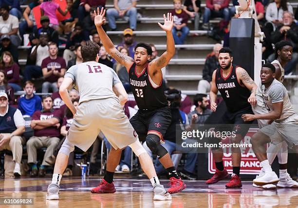 Louisiana Lafayette Ragin Cajuns forward Bryce Washington guards Arkansas Little Rock Trojans forward Lis Shoshi during an NCAA basketball game...
