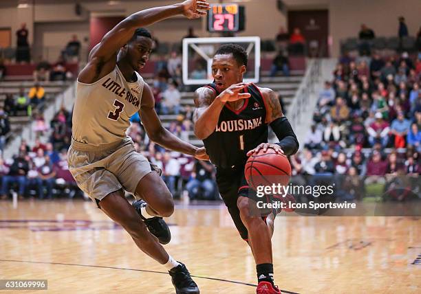 Arkansas Little Rock Trojans guard Andre Jones defends the goal from Louisiana Lafayette Ragin Cajuns guard Jay Wright during an NCAA basketball game...